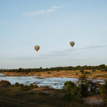 Hot air balloons over a river at sunrise, Tanzania, Yellow Zebra Safaris
