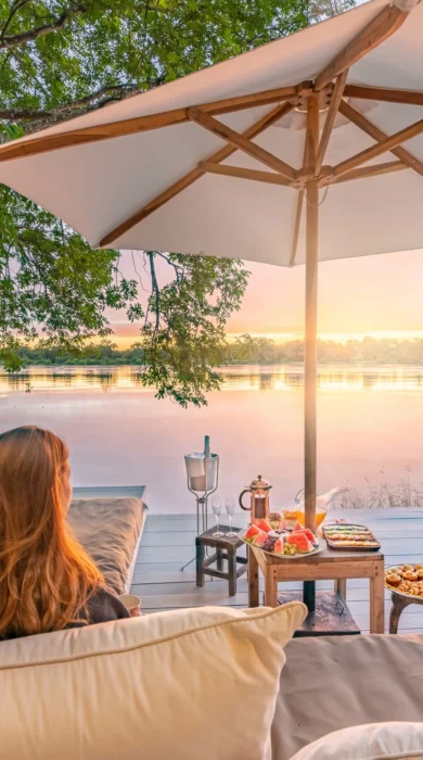 couple watching the sunset, time and tide chinzombo, south luangwa national park, zambia