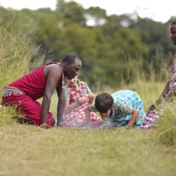 Guides help a child start a fire, Kicheche, Mara, Kenya - Yellow Zebra Safari