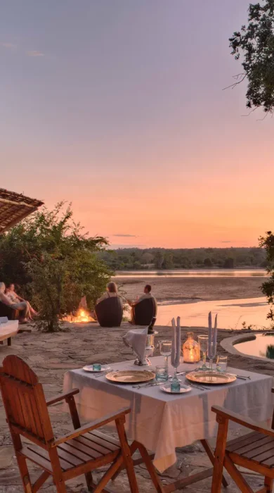 An outdoor patio area with a plunge pool, sun loungers and a table set for dinner, Tanzania - Yellow Zebra Safari