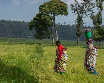 Rwandans walk in the field, Volcanoes National Park, Rwanda - Yellow Zebra Safaris