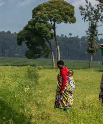 Rwandans walk in the field, Volcanoes National Park, Rwanda - Yellow Zebra Safaris