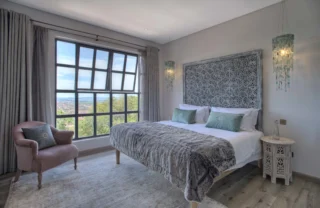 A double bed with grey bedding at Latitude 0 Degrees, Kampala, Uganda - Yellow Zebra Safaris